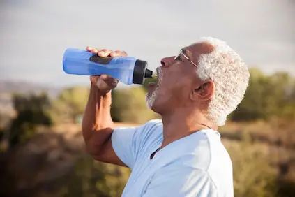 男人从水瓶里喝水。