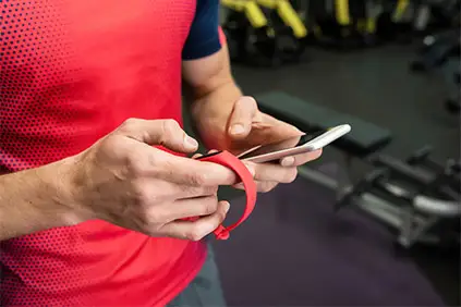 Man using fitness tracker and smartphone app.