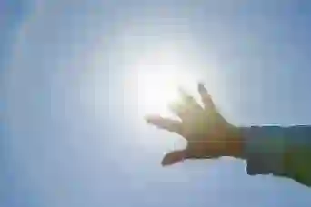 一个女人对着太阳举起手