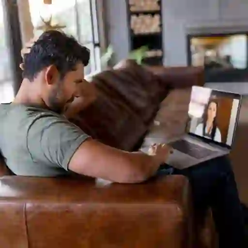 一个男人在笔记本电脑上与医生交谈