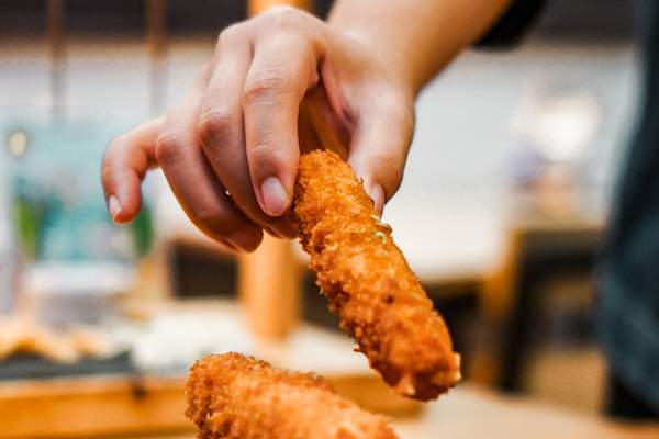 手拿起炸马苏里拉奶酪条