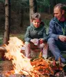 坐在篝火附近的父亲和儿子。