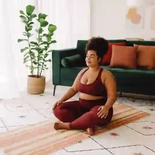 一个女人坐在瑜伽垫上并冥想
