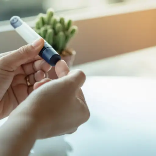 近距离观察女性双手,用手指上的刺针用葡萄糖仪检查血糖水平