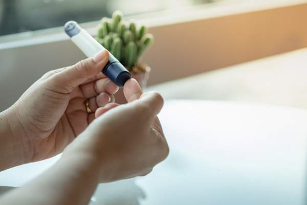 关闭女人的手了使用手指采血检查葡萄糖METE血糖水平