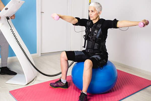 穿着机器人套装锻炼的资深女性。