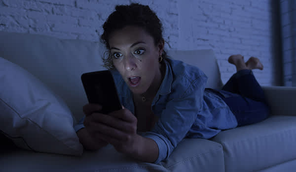 女人躺在沙发上用手机上网