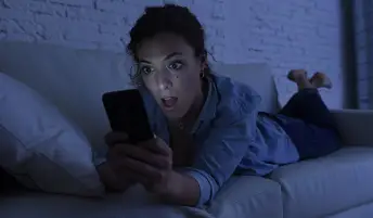 躺在沙发上的女人使用手机互联网