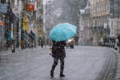 暴风雪中带着蓝色雨伞的人
