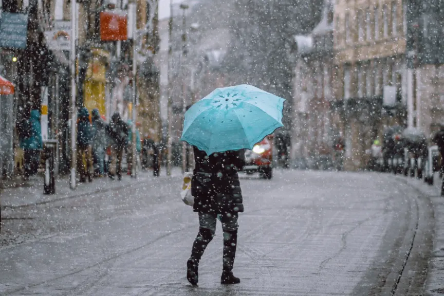 有蓝色的雨伞在暴风雪的人
