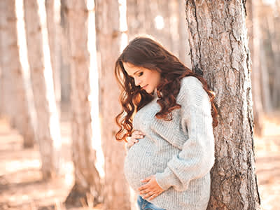 一棵树旁有个怀孕的女人。