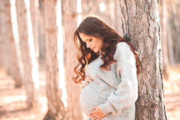 一棵树旁有个怀孕的女人。