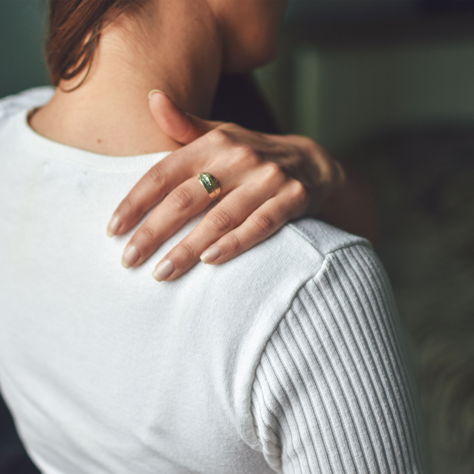 一个女人痛苦地抚摸着她的肩膀