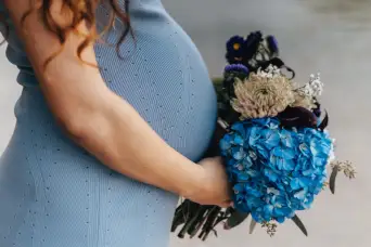 抱着蓝色花朵的孕妇
