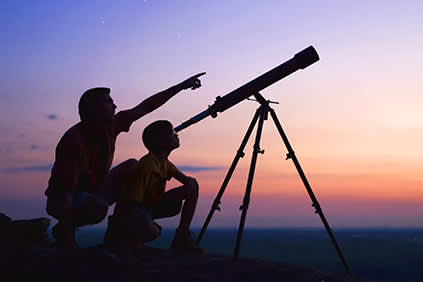 父亲和儿子调查望远镜。