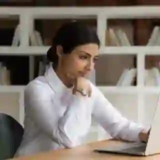 A woman looks at her laptop