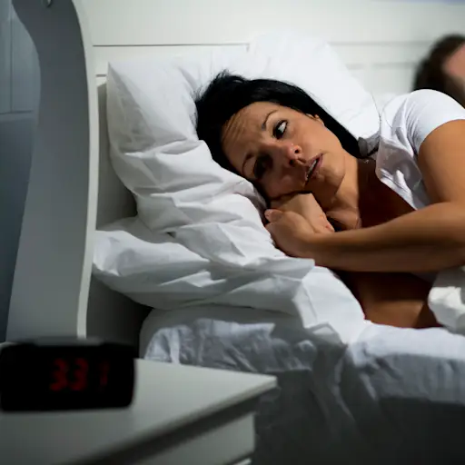 Couple wwake in bed, unable to sleep.
