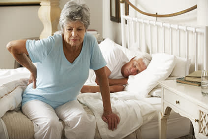 上了年纪的妇女下床时背痛。