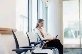 一个女人在医院的候诊室看着她的电话