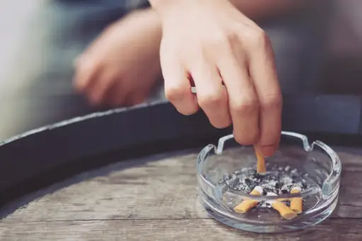 hand putting out cigarette in ashtray