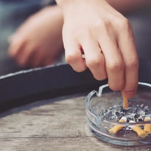 hand putting out cigarette in ashtray