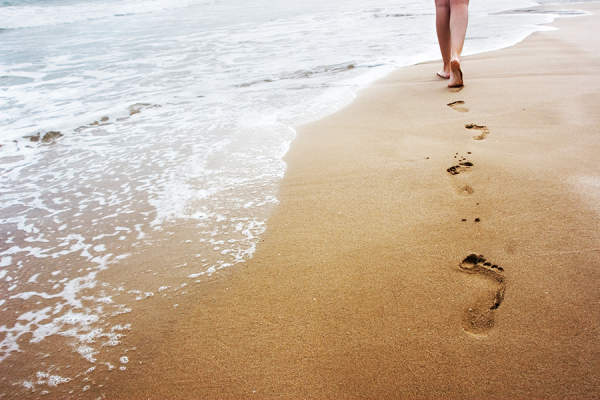 在沙滩上留下脚印的女人