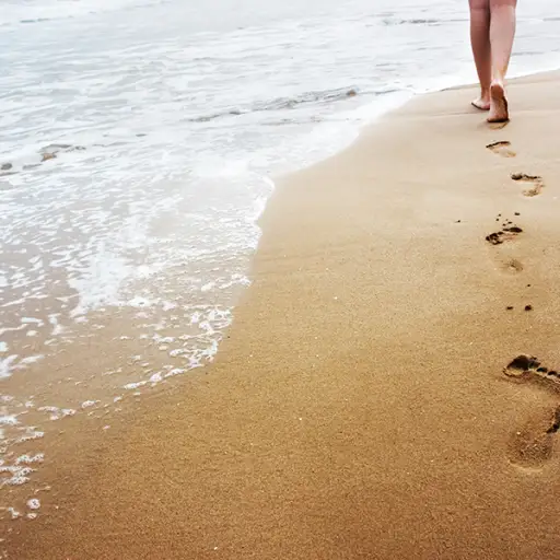 留下脚印的妇女后边海滩