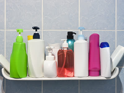 浴室的架子上有许多洗发精和肥皂瓶。