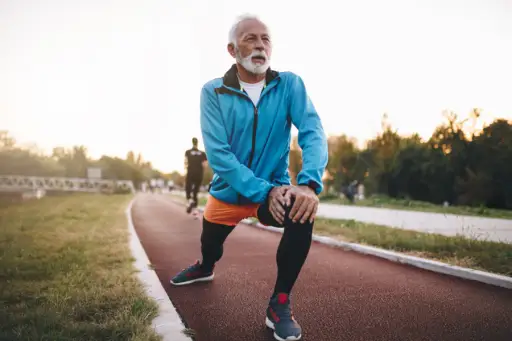 老人在跑道上慢跑时伸展身体