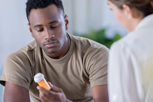 男人在军队与医生和处方药。