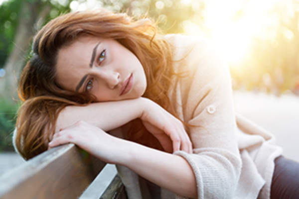 不幸的女人在公园的长椅上。