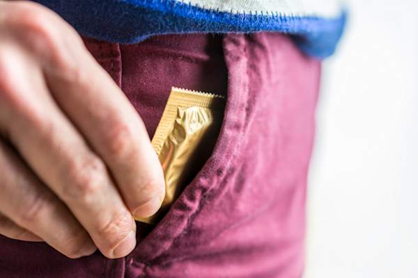 男人从口袋里掏出避孕套