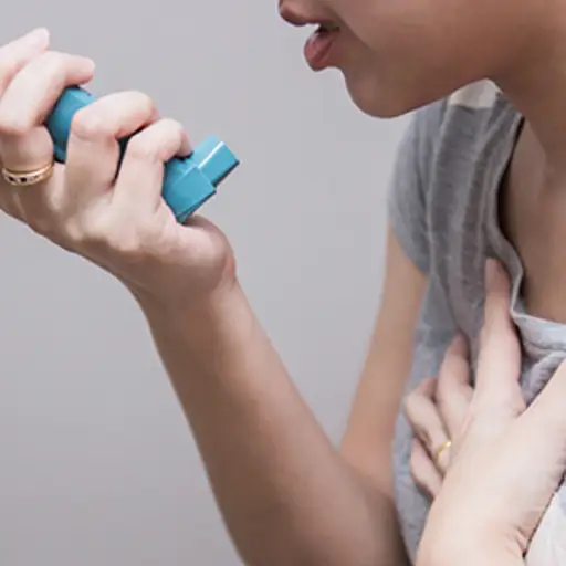 女人使用吸入器。
