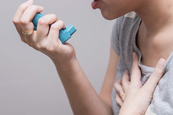 女人使用吸入器。