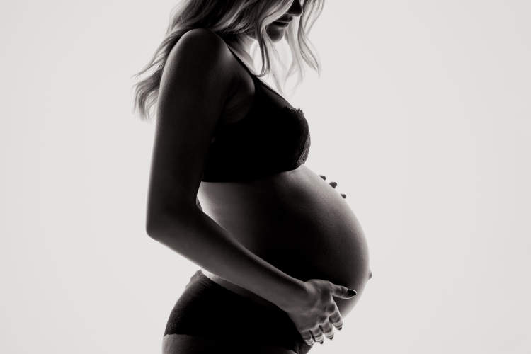 黑白图像的孕妇抱着胃