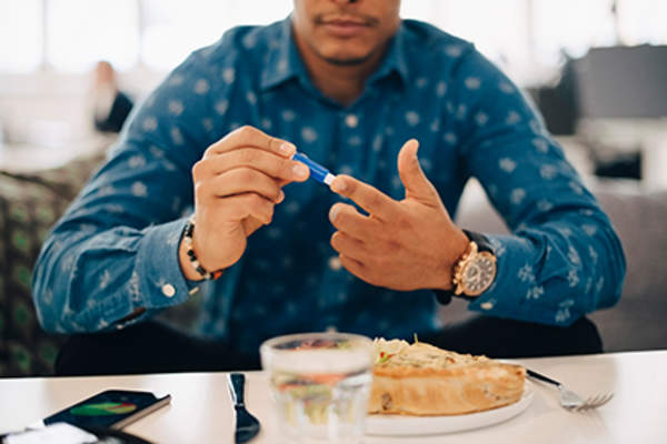 一个人在饭前检查他的血糖。