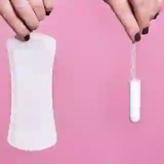 Women holding a sanitary napkin and tampon.