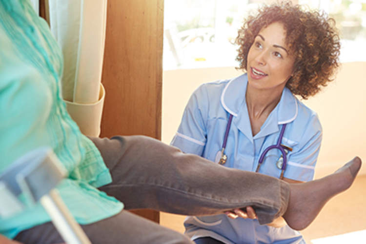 物理治疗师帮助帮助移动他的腿。