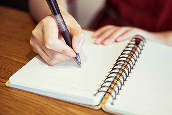 女人在笔记本上写字。