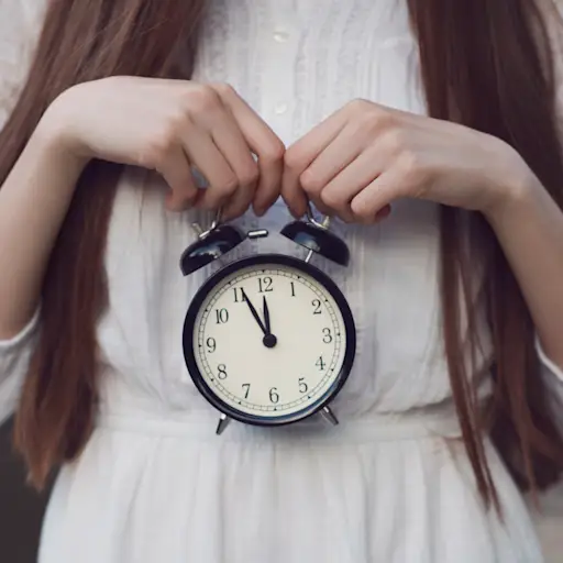 女人,谁的头没有框架,拿着一个小的圆形时钟