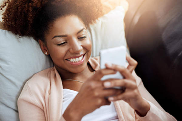 女子面带微笑,并用生育跟踪应用程序。