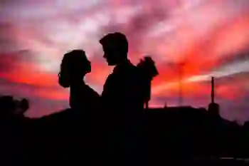 silhouette of couple looking at each other at sunset