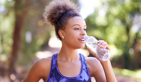 女人饮用水，同时锻炼。