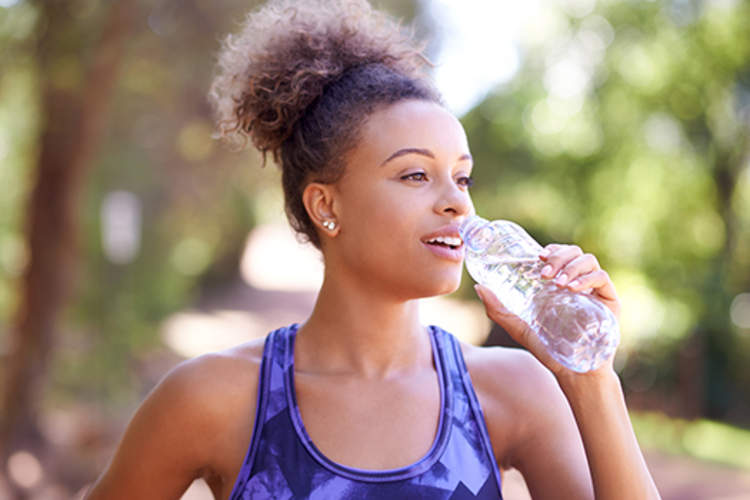 女人饮用水,同时锻炼。
