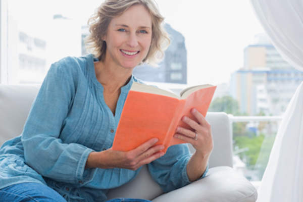 在窗口前读取妇女坐在椅子上。