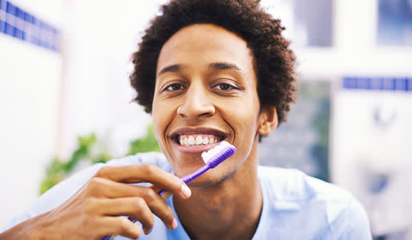 微笑的年轻人刷牙的形象。