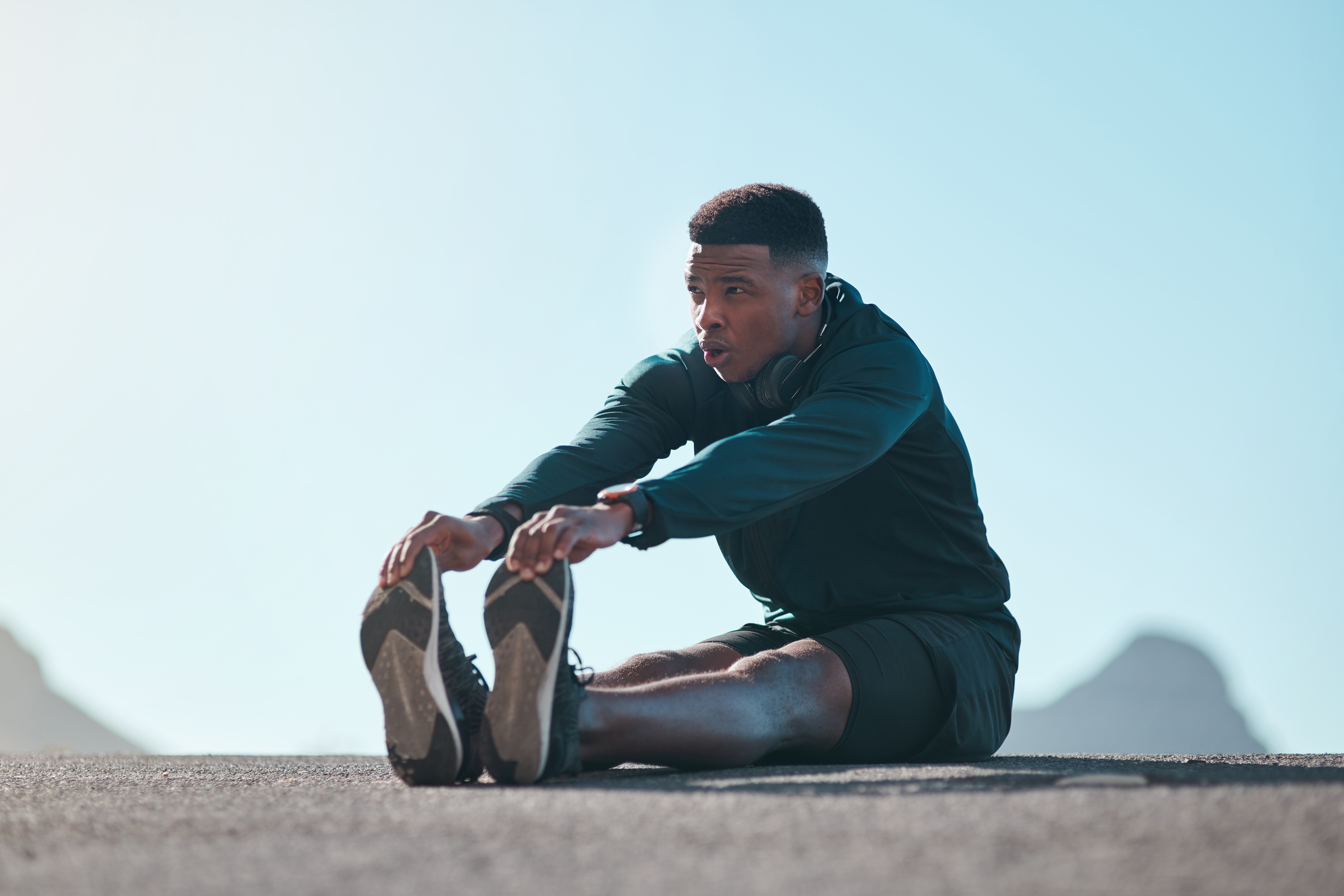 Young man sitting alone and stretching his hamstrings