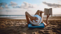 一个女人在海滩上看书。