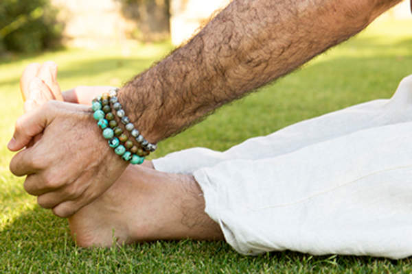 男人在水疗馆瑜伽课外做伸展运动。