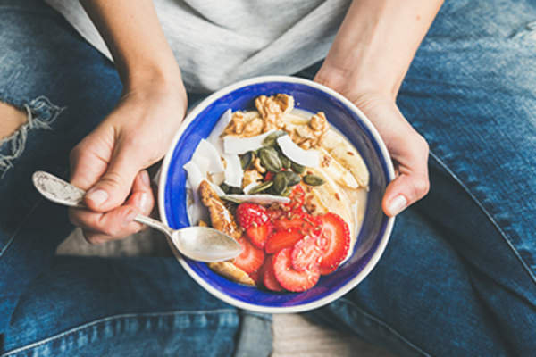酸奶,格兰诺拉麦片,种子,新鲜干果和蜂蜜在碗。